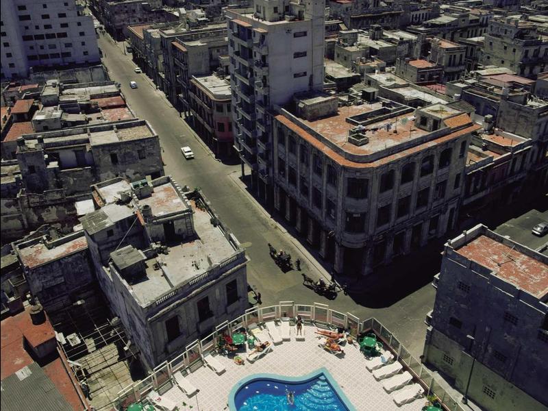 View of a city with multiple buildings and a hotel rooftop pool.