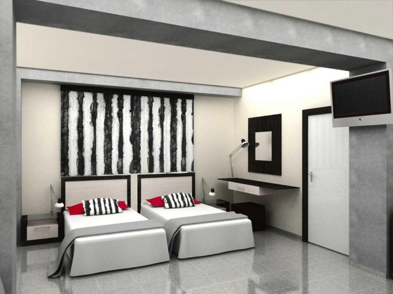 Modern hotel room with two single beds, carpeted floor, and wall-mounted TV.