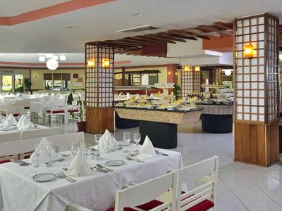 Elegantní jídelna s prostřenými stoly a bufetem.