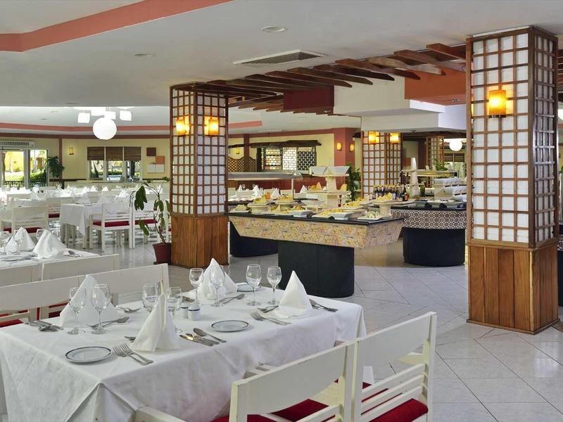 Elegantní jídelna s prostřenými stoly a bufetem.