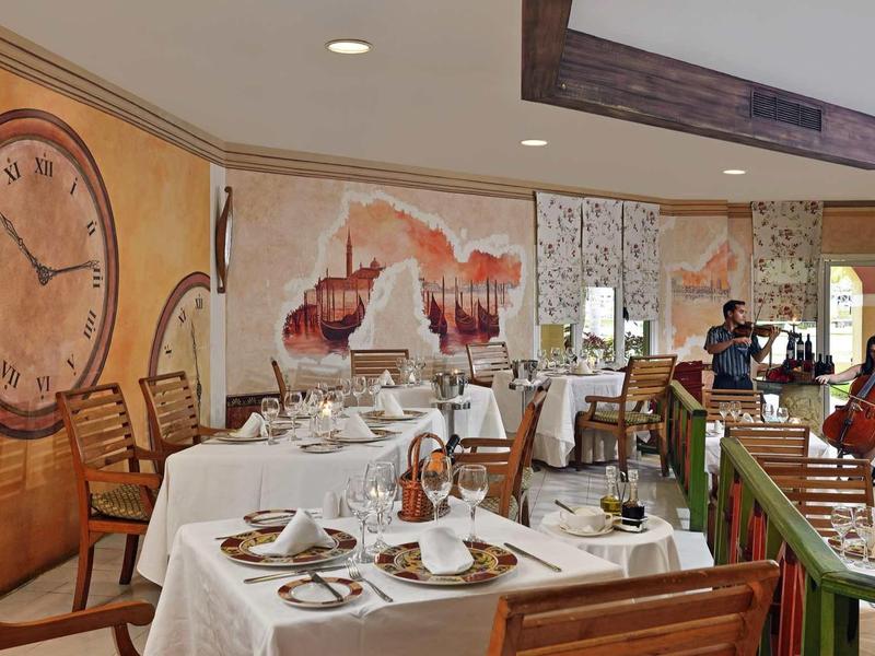 Elegantní restaurace s prostřenými stoly a teplými dekoracemi na stěnách.