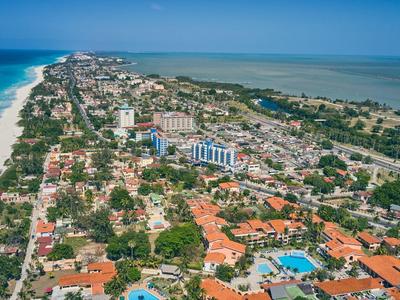 Vista aerea di una città costiera con hotel, spiagge e acqua limpida e blu.