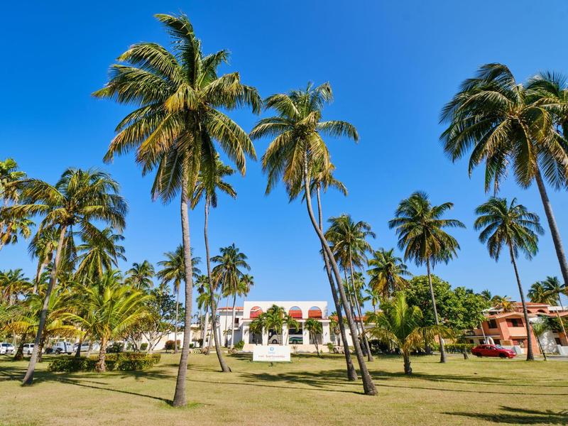 Hotel con palme e cielo blu in un ambiente tropicale.