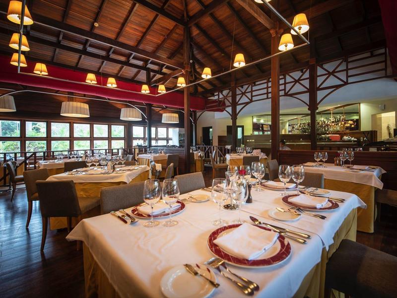 Ristorante elegante con tavoli apparecchiati e soffitto in legno rustico