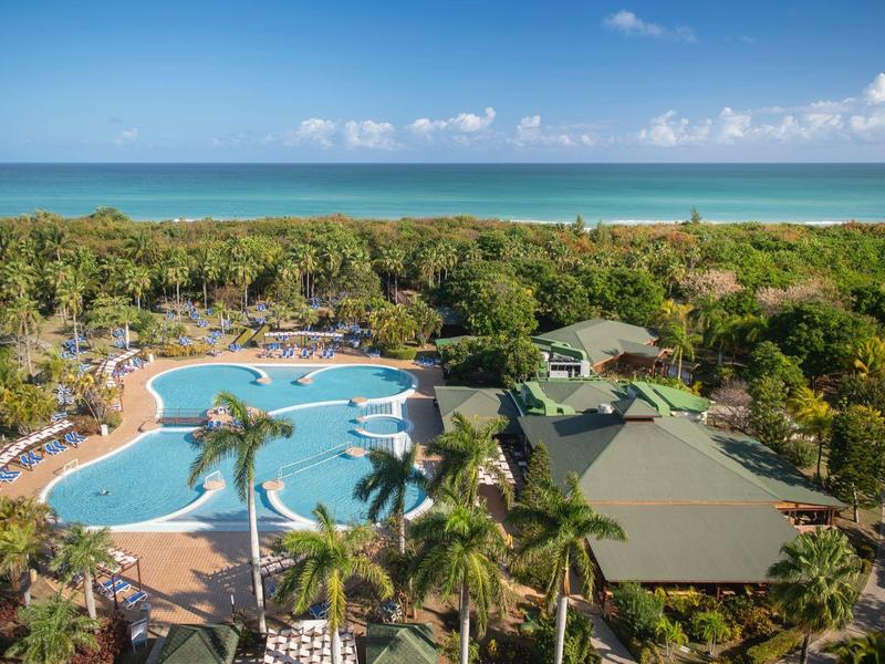 Vista di un complesso alberghiero tropicale con piscina e mare sullo sfondo