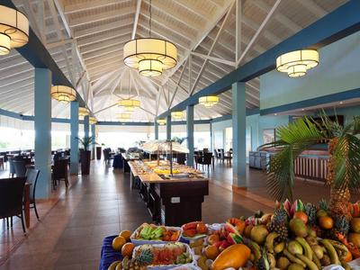 Large hotel dining hall with buffet and bowls of fresh fruit.