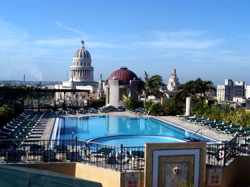 Stadsgezicht met historische gebouwen en weelderig groen onder een heldere hemel