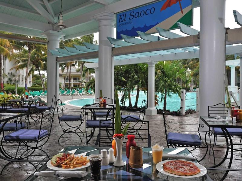 Terrazza del ristorante con vista sul mare e piatti sui tavoli.
