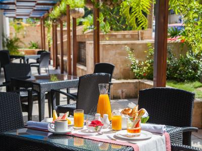 Terrace with set table, juice pitcher, and breakfast by outdoor seating area.