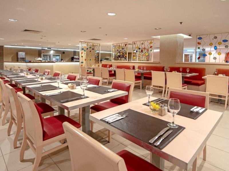 Restaurant d'hôtel moderne avec banquettes rouges et tables dressées