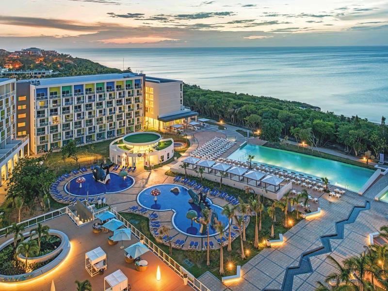 Hotel di lusso con piscine e vista mare al tramonto.