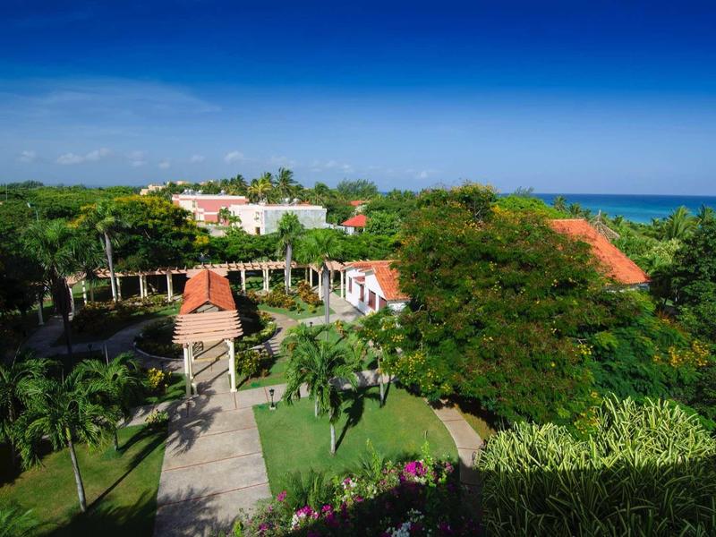 Hotel in ambiente tropicale con più edifici e vista sul mare blu.
