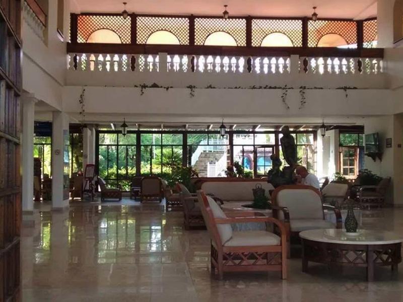 Ampia hall dell'hotel con mobili imbottiti e grandi finestre che lasciano entrare la luce del giorno.