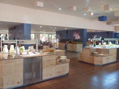 Área de buffet con varios platos y luz cálida en un restaurante de hotel