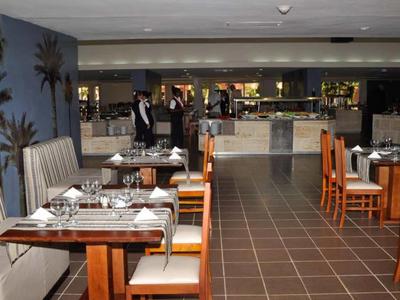 Ristorante moderno con tavoli in legno, sedie confortevoli e illuminazione elegante.