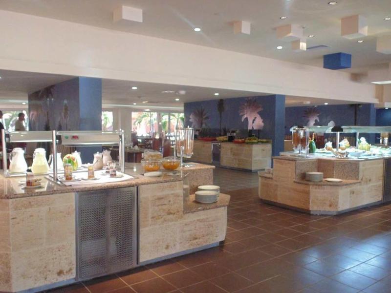 Area buffet con vari piatti e mobili moderni in legno in un ristorante di un hotel.