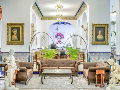 Salon d'hôtel élégant avec art classique, mobilier et statues dans un intérieur lumineux.