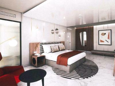 Modern hotel room with bed, seating area, and abstract wall art.
