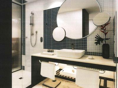Modern bathroom with round mirror, double sinks, and towels in a hotel.