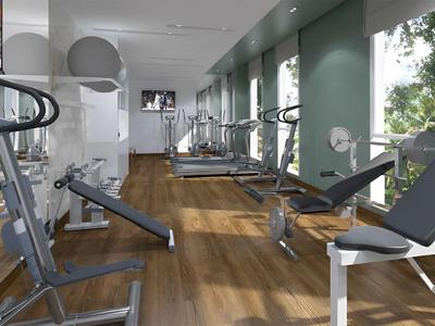 Salle de sport moderne avec équipements et grandes fenêtres laissant entrer la lumière du jour.