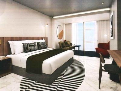 Modern hotel room with large double bed, seating area, and balcony access.