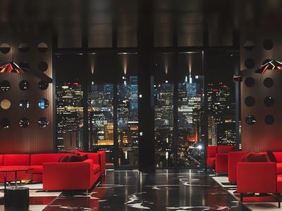 Luxurious hotel lounge with red sofas and a nighttime city view.