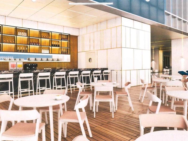 Modern bright bar area with white chairs and wooden floor in a hotel.