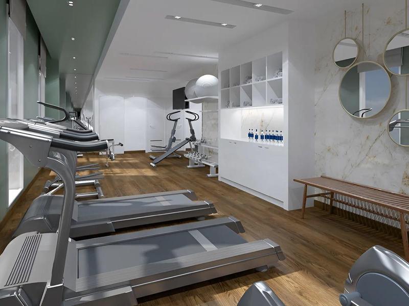 Modern gym with several treadmills, white walls, and large windows.