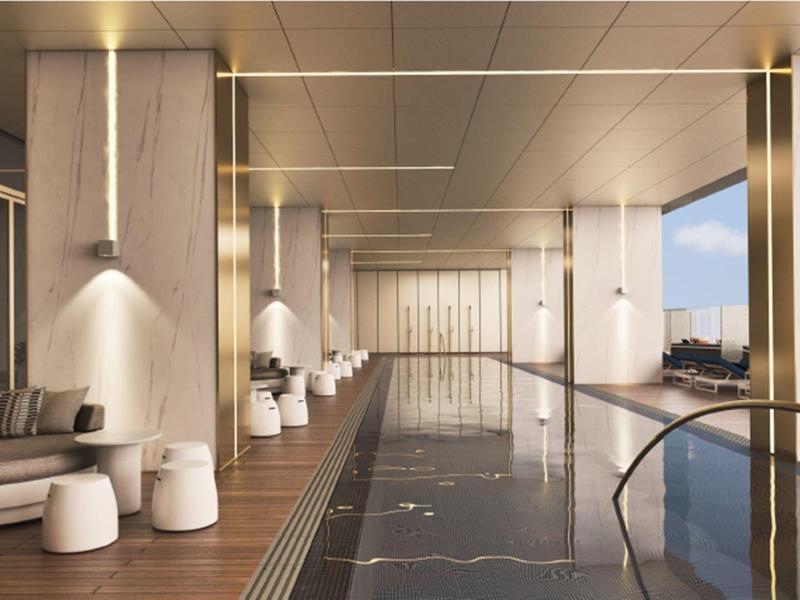 Modern indoor hotel pool with wooden ceiling and large window view.