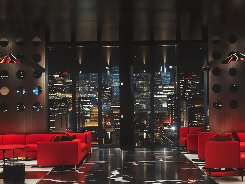 Luxurious hotel lounge with red sofas and a nighttime city view.