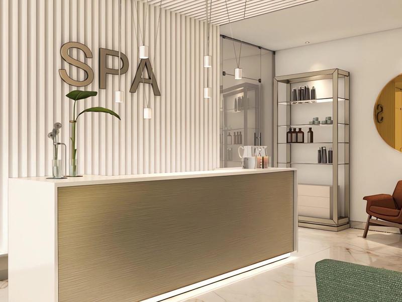 Modern spa reception area with illuminated counter and cozy chairs.