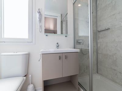 Modern bathroom with toilet, vanity cabinet, and glass-door shower