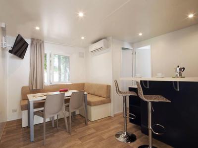 Modern dining area with table, chairs, and bar counter in a bright room.