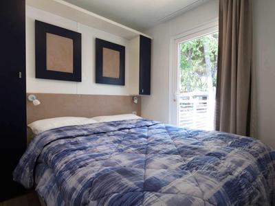 Cozy bedroom with large window and blue patterned bedspread.