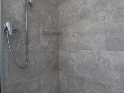 Aerial view of a resort with pools, sun terraces, and lush greenery near the water.