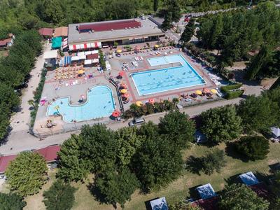 Luftbild eines Freibads mit zwei großen Schwimmbecken und umliegenden Grünflächen.