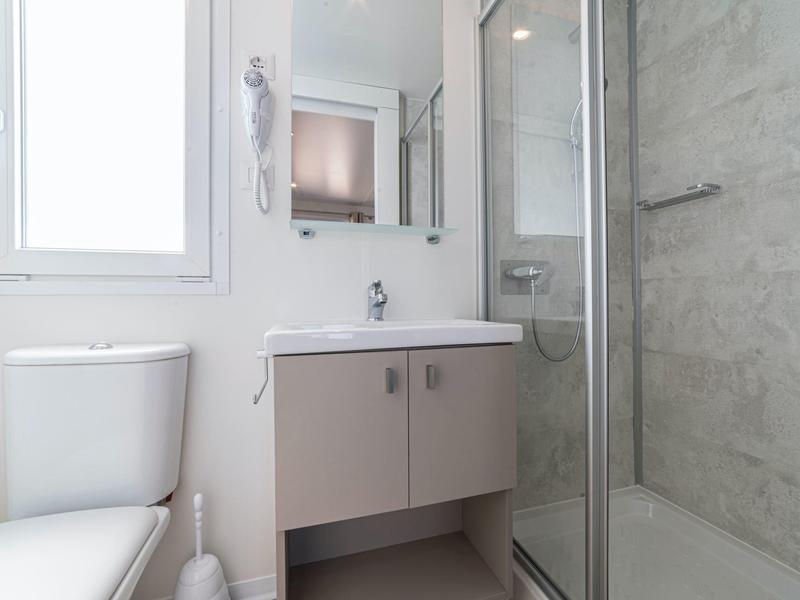 Modern bathroom with toilet, vanity cabinet, and glass-door shower