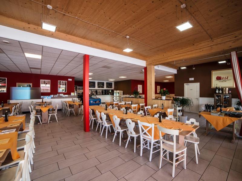 Large dining room with wooden tables and chairs in a hotel restaurant.