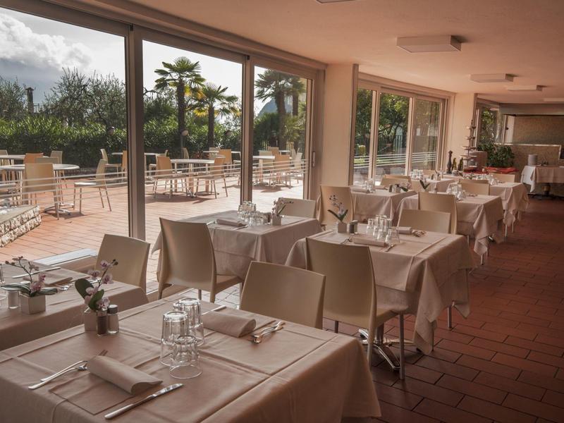 Elegant restaurant with set tables and view of a terrace garden.