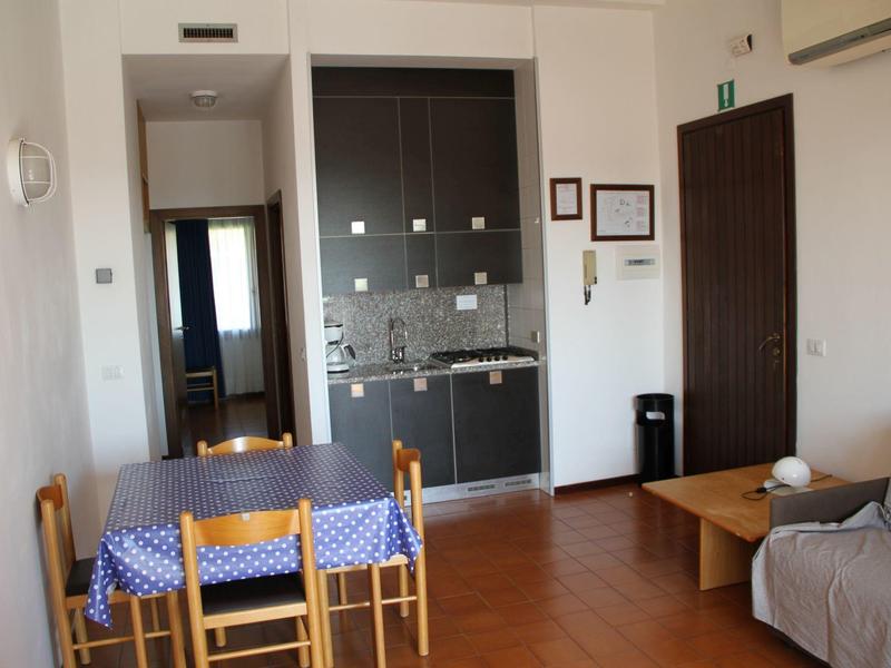 Small kitchenette with dining table and chairs in a simple living space.