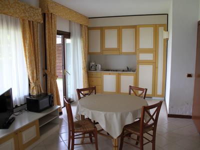 Dining area with round table, four chairs, and built-in cabinet in bright room.