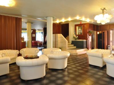 Cozy hotel lobby with cream armchairs and warm lighting.