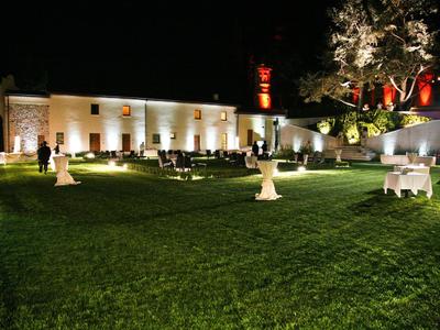 Giardino di hotel illuminato con prato verde e mobili bianchi di notte.