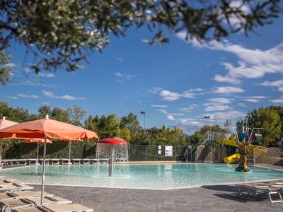 Außenpool mit Sonnenschirmen und Liegestühlen unter blauem Himmel