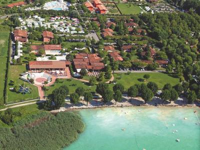 Letecký pohled na rezort s bazénem, budovami a břehem u čistého jezera.