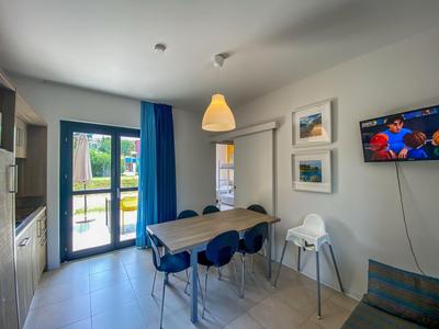 Moderner Essbereich mit Tisch, vier Stühlen und Zugang zu einer Terrasse in einem Hotelzimmer.