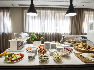 Bufet z wyborem wykwintnych potraw i wypieków w jasnym, nowoczesnym pomieszczeniu.