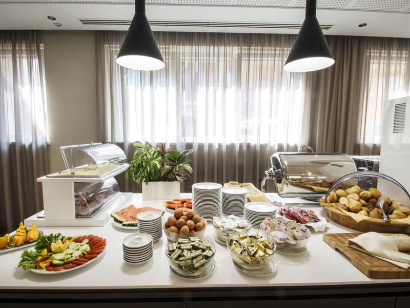 Bufet z wyborem wykwintnych potraw i wypieków w jasnym, nowoczesnym pomieszczeniu.