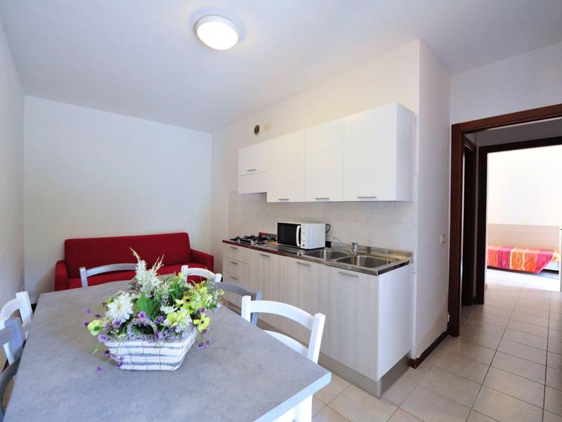 Small kitchenette and dining area with table and chairs in a hotel apartment.