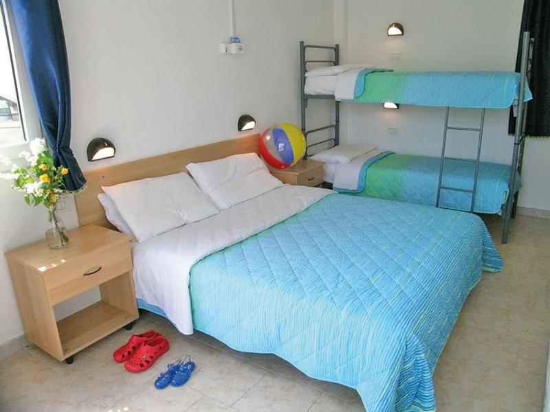 Bedroom with double bed, bunk bed, nightstand, and colorful ball in bright room